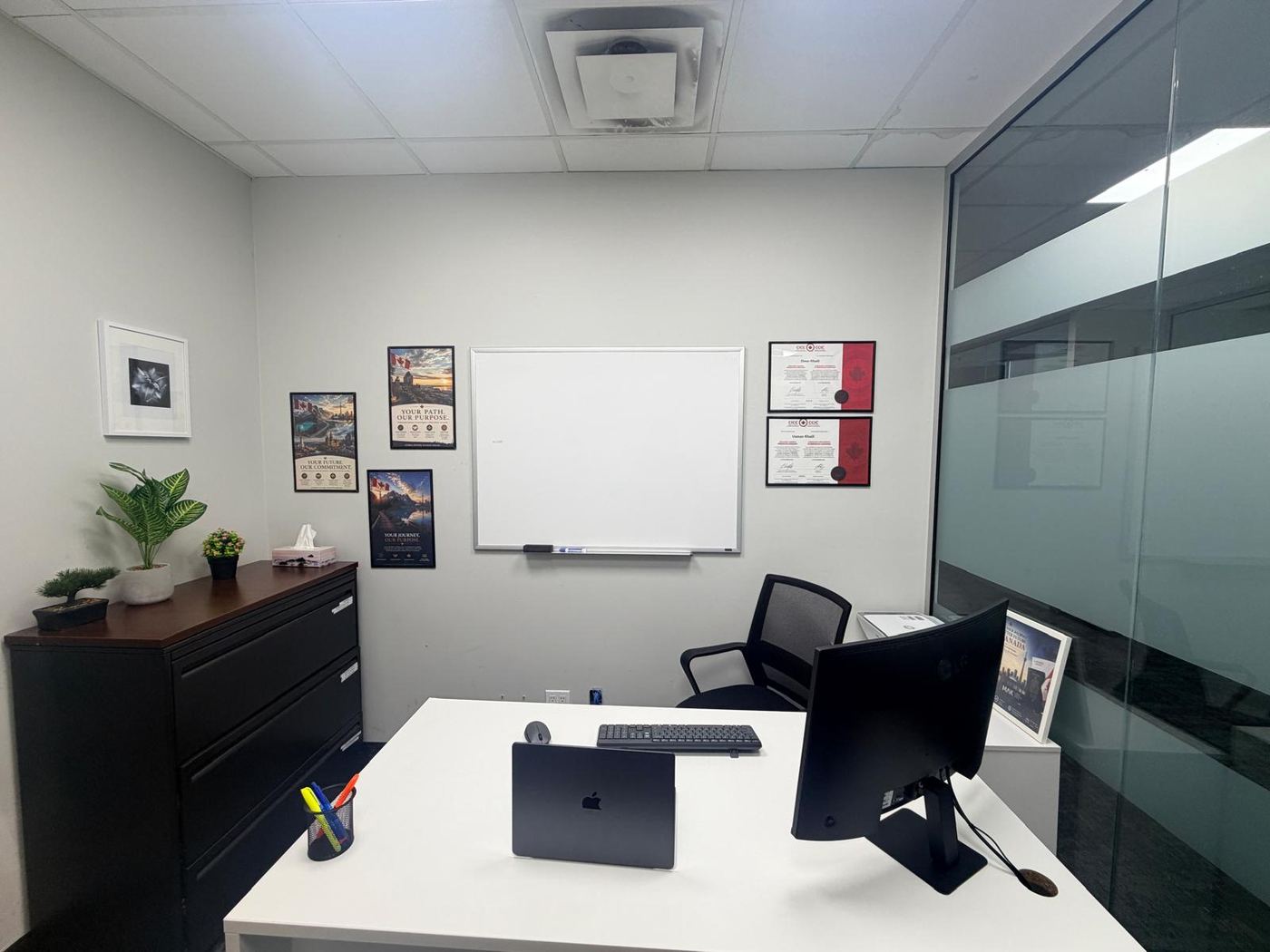 Consultation room at the MAK Scarborough immigration office showing both framed CICC licence certificates