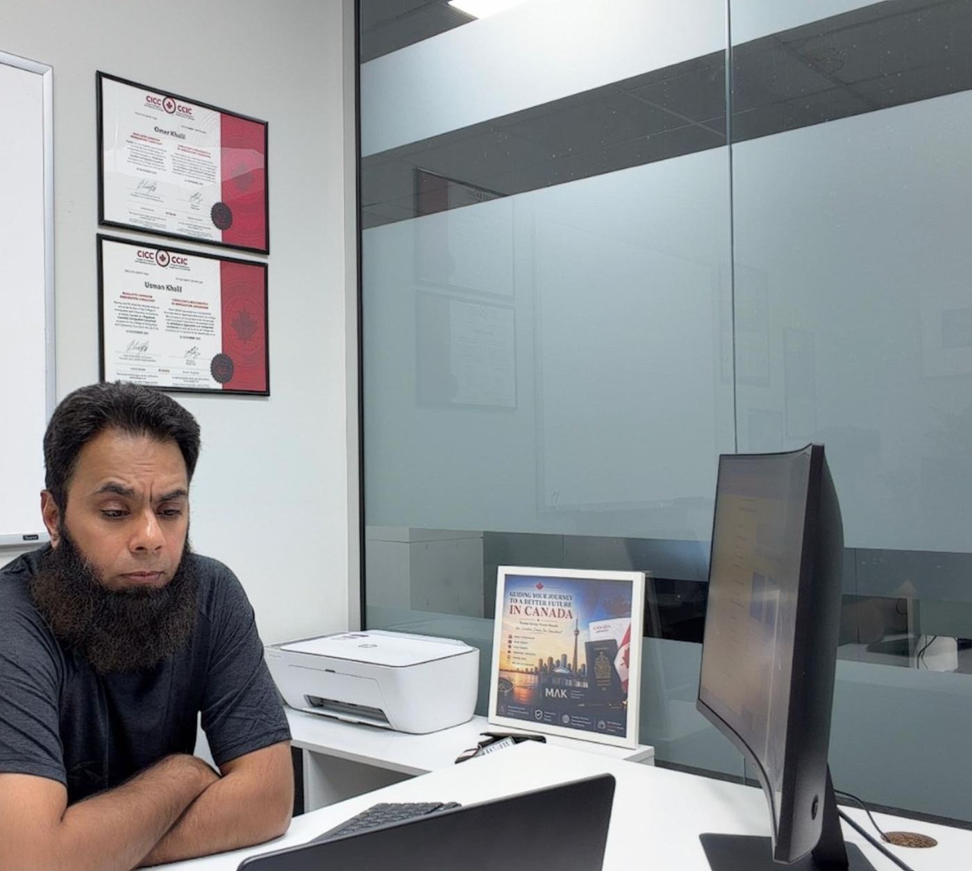 Framed CICC licence certificates for RCIC Omer Khalil and RCIC Usman Khalil at the MAK Scarborough office